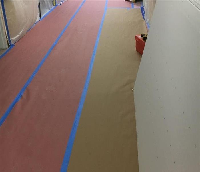 A hallway taped off with paper.