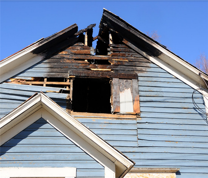 a fire damaged blue roof of a house