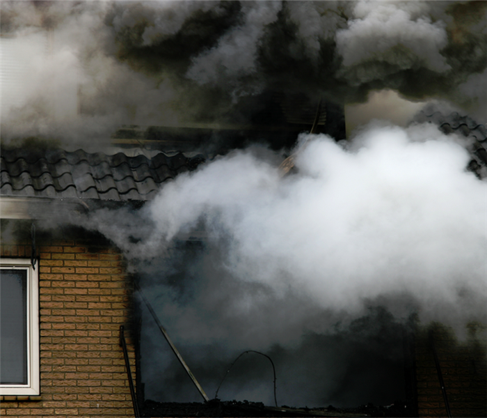 smoke billowing from the windows of a house